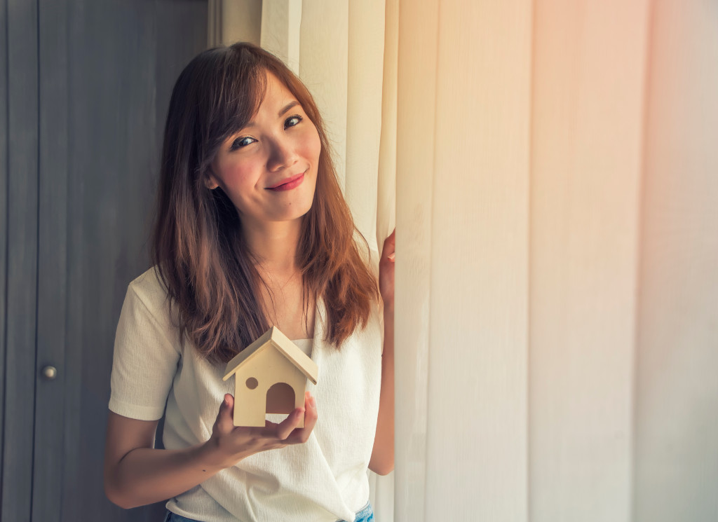 woman holding a toy house