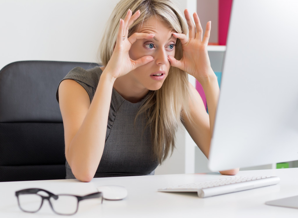 woman keeping eyes open at work
