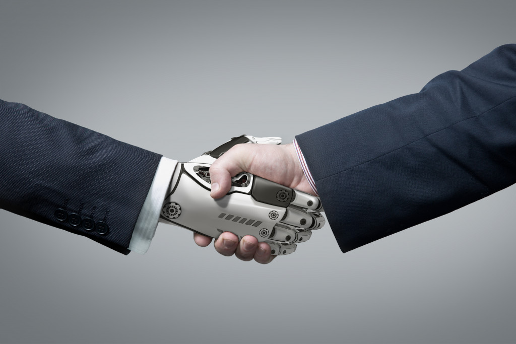 a robot and person shaking hands
