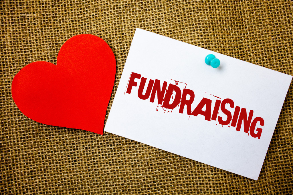 Conceptual hand writing showing Fundraising. Business photo text Seeking of financial support for charity cause or enterprise Message note jute background red heart letters love grunge idea.