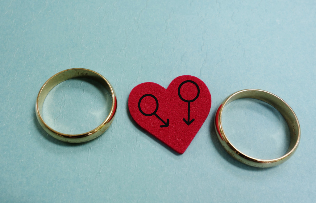 A red heart with two male symbols and a pair of wedding rings