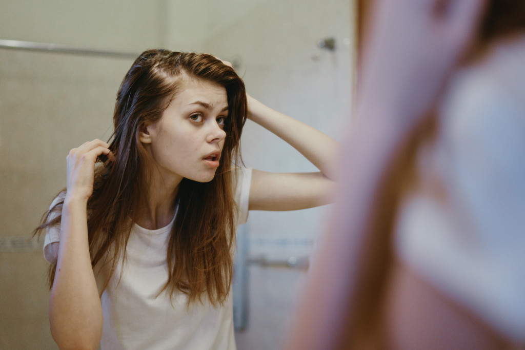 woman hair loss looking at the mirror